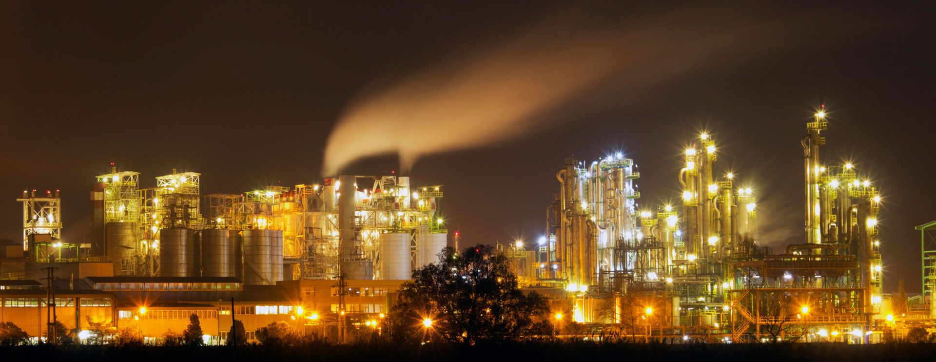 Eine stark beleuchtete Industrieanlage bei Nacht